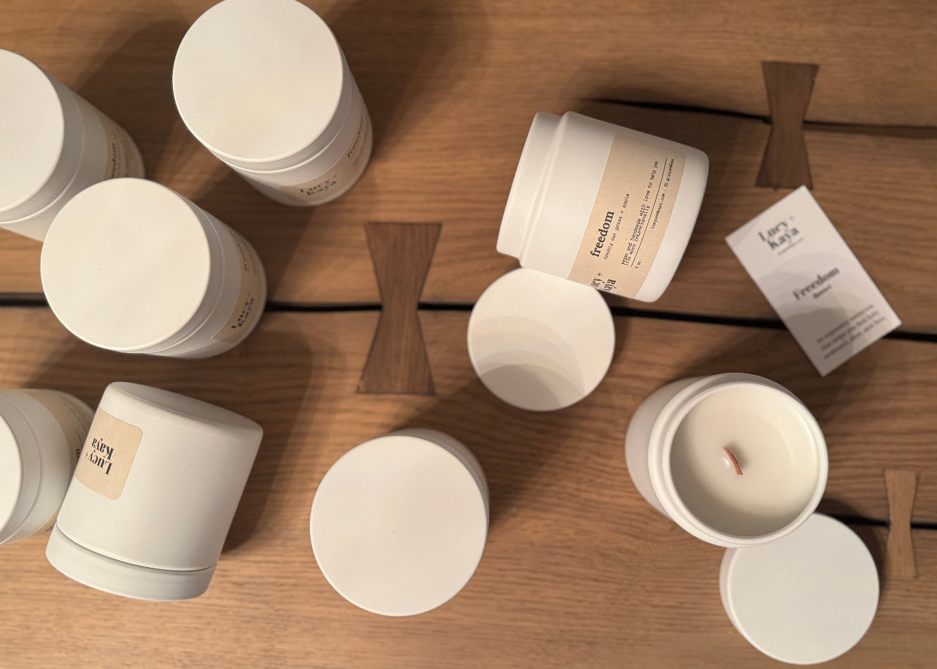 White containers with wooden spoons on a wooden surface